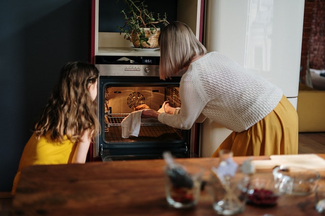 mother and child baking a cake in the oven