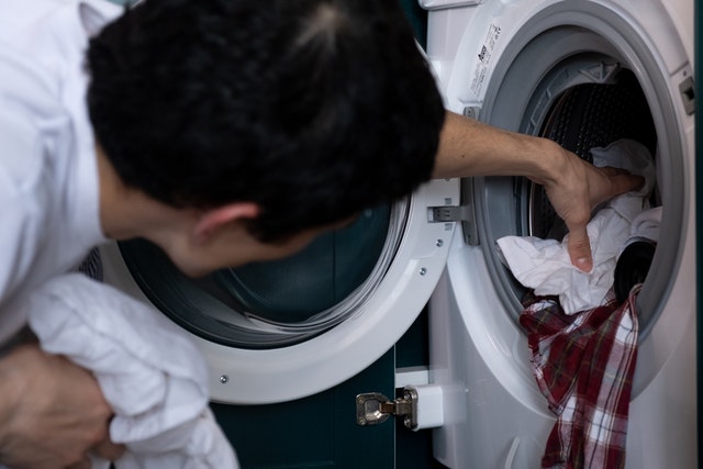man taking clothes of the dryer